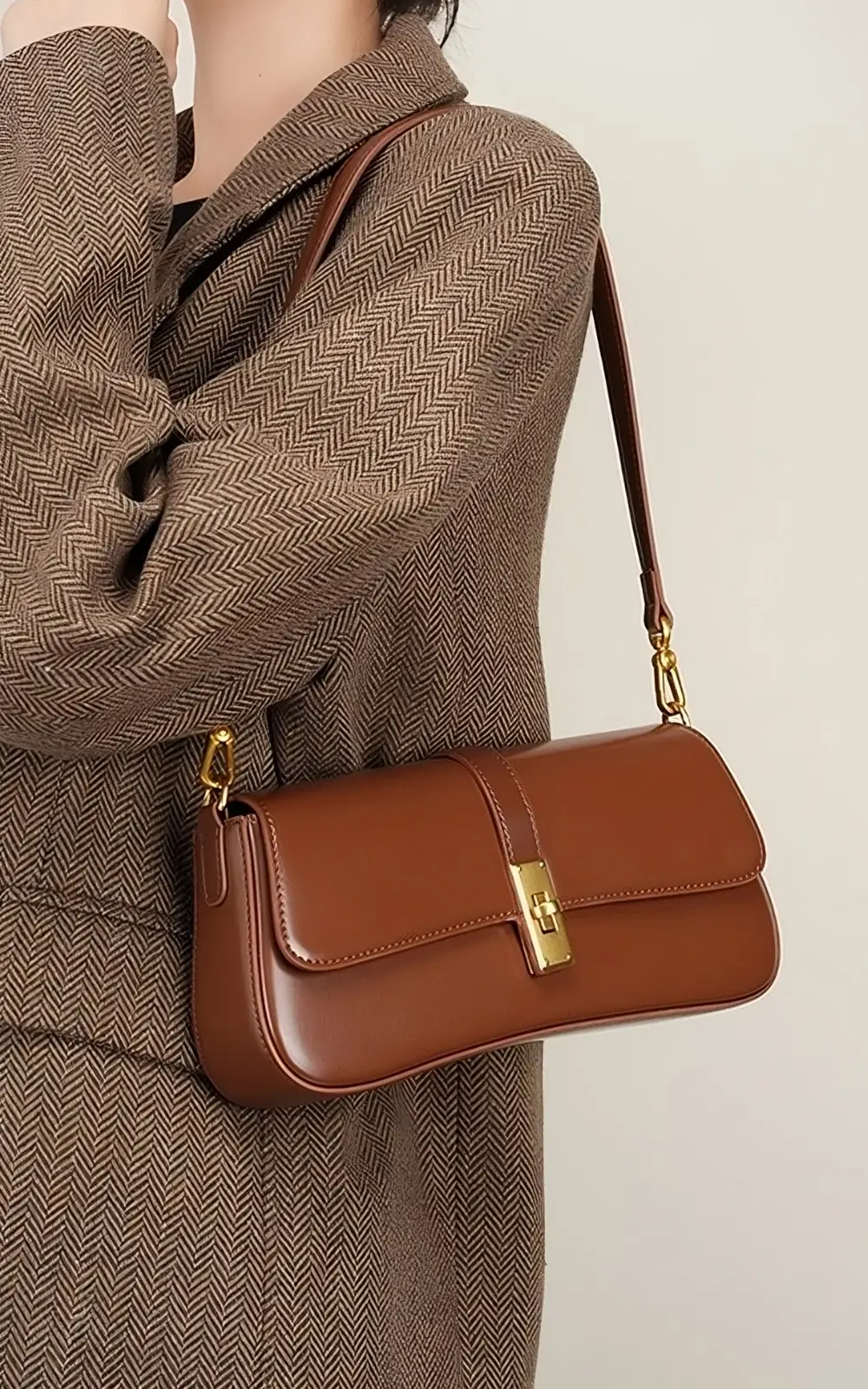 Close-up of brown calfskin texture and gold-tone clasp detail