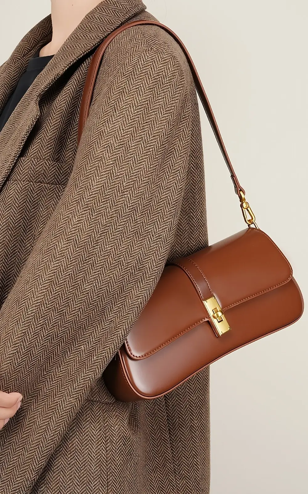 Brown Marisse Baguette Bag worn over the shoulder, showcasing elegant flap and gold-tone clasp