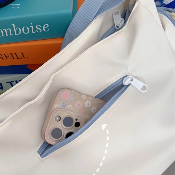 Back view of cream ita bag showing hidden anti-theft zipper pocket with water droplets on water-resistant surface