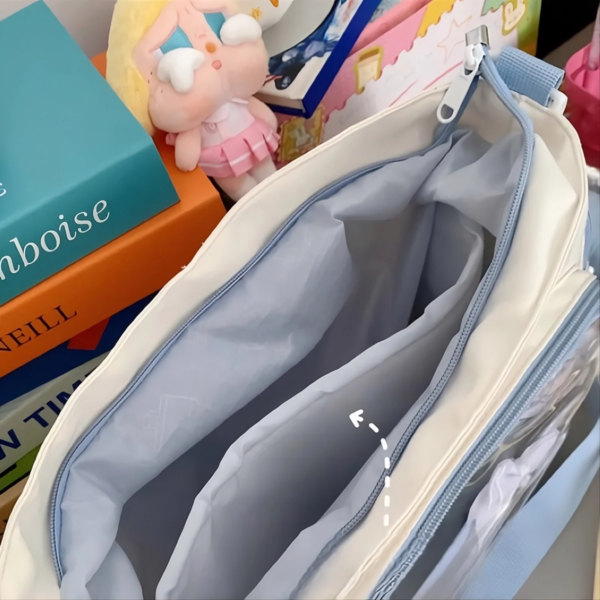 Inside view of cream ita bag showing padded internal divider and dual zipper compartments