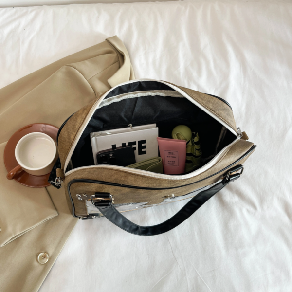 Inside of denim ita bag showing cream lining, internal zipper pocket, and keychain clip