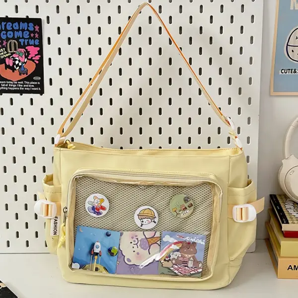 Khaki ita bag hanging on pegboard, decorated with earth-toned badges and bear charm