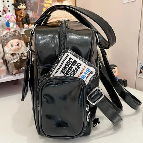 Side profile view of black ita bag showing multiple exterior pockets and silver hardware