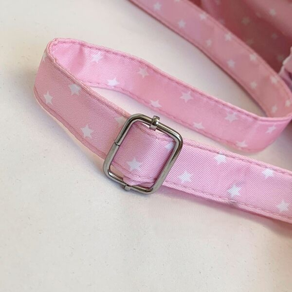 Close-up of adjustable nylon shoulder strap with silver metal slider on pink star patterned ita bag