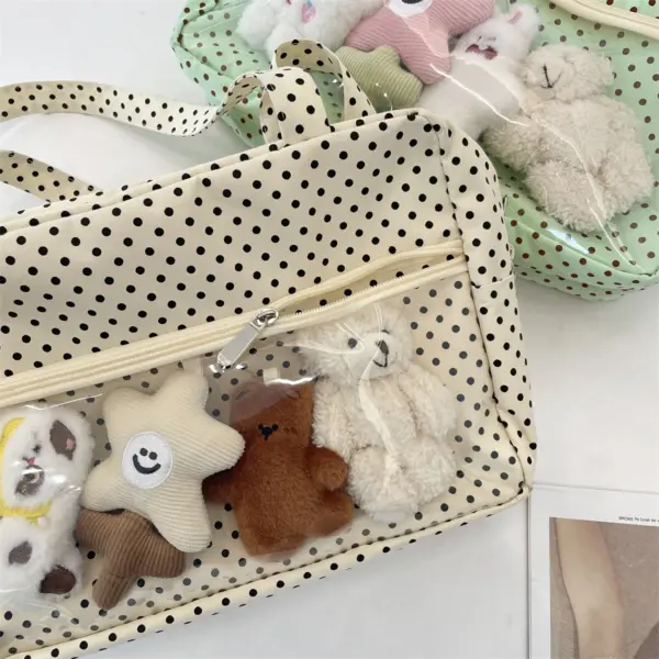 Close-up of cream polka dot ita bag with plush toys inside clear window