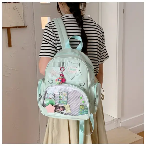 Ita backpack on person displaying pins through clear window