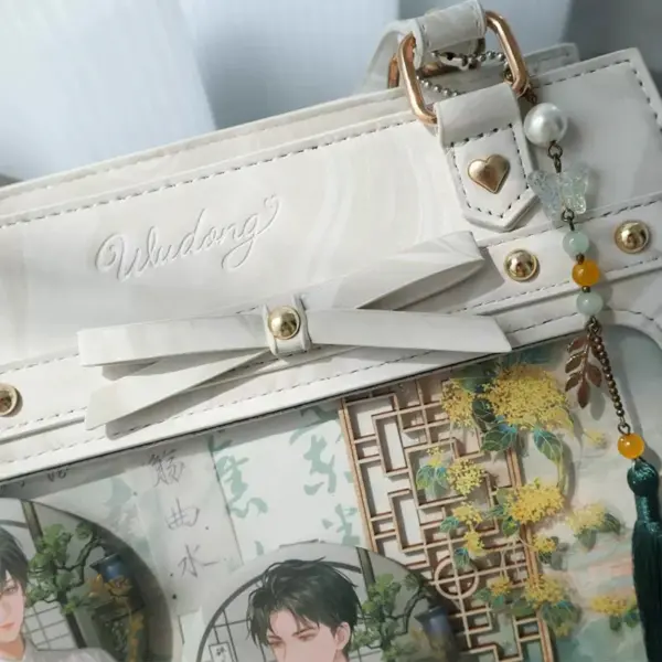 Close-up of bow and charm details on white ita bag