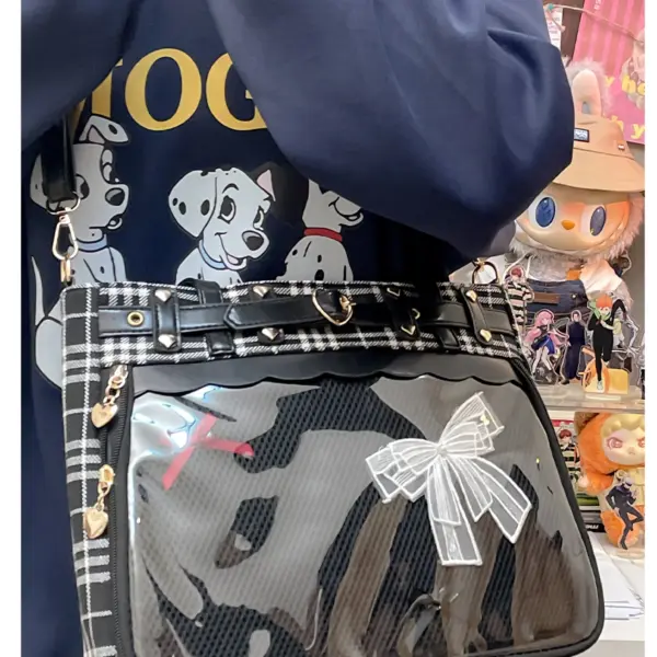 Ita bag held by person showing clear window and red plaid side panel
