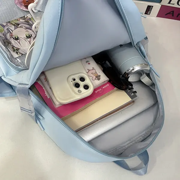Front view of cream ita backpack with pins and plush display