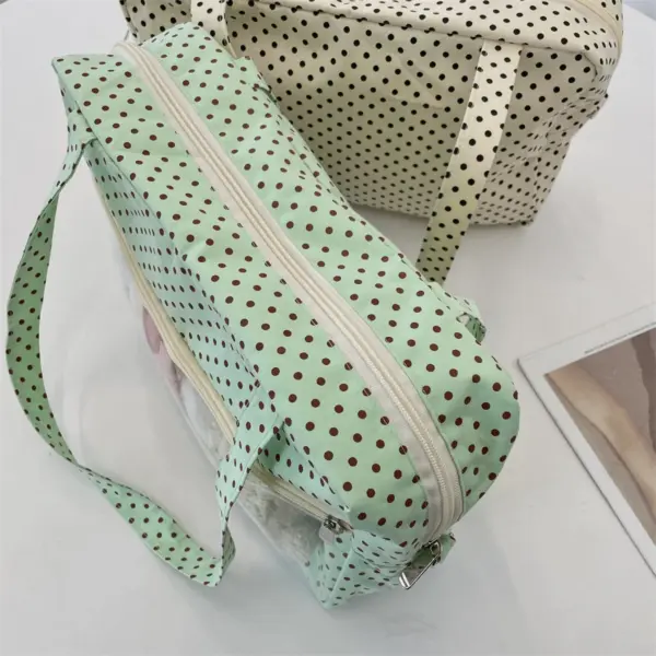 Rear three-quarter view of mint green polka dot ita bag showing handle stitching and base