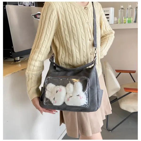 Person wearing dark grey ita bag crossbody with plush toys visible