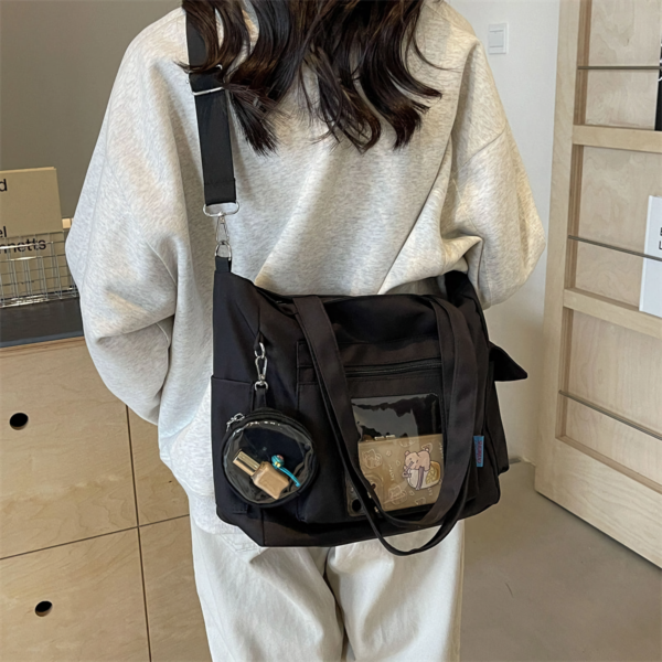 Person Wearing Black Ita Bag Over Shoulder