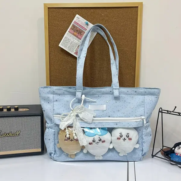 Light Blue Ita Bag Displaying Three Plush Dolls