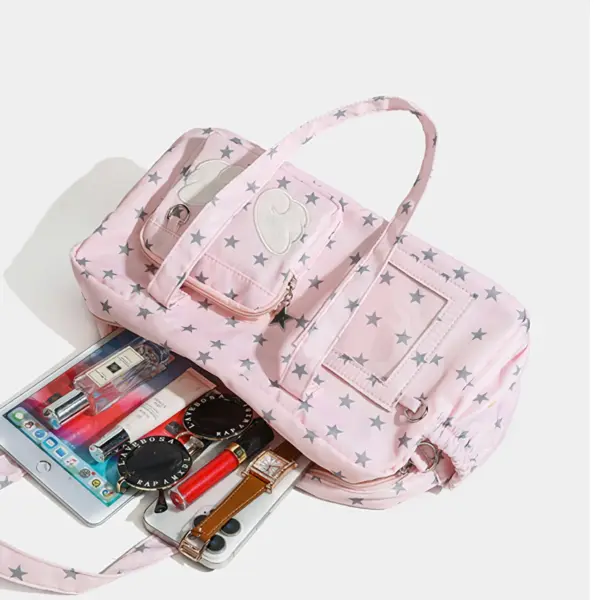 Top view of ita bag open with pens, lipstick, and keychains inside