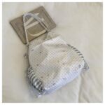 White Polka Dot Ita Bag Flat Lay Next to Notebook