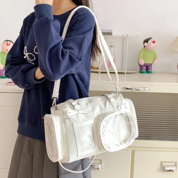 White Ita Bag Held by Person in Dark Sweater White Ita Bag Held by Person in Dark Sweater