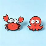 Crab and Octopus Enamel Pins on Blue Background